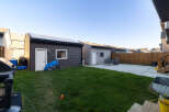 Discover this spacious backyard featuring a well-maintained lawn and a concrete patio, perfect for outdoor entertaining.