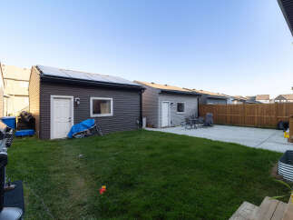 Discover this spacious backyard featuring a well-maintained lawn and a concrete patio, perfect for outdoor entertaining.