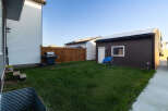 Discover this charming backyard featuring a well-maintained lawn, perfect for outdoor activities.