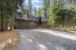 Nestled amongst tall pine trees, this charming brown home offers a serene retreat.