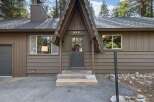Charming A-frame home with a rustic brown exterior, featuring a welcoming covered porch with a glass-paned door and house number '620'.