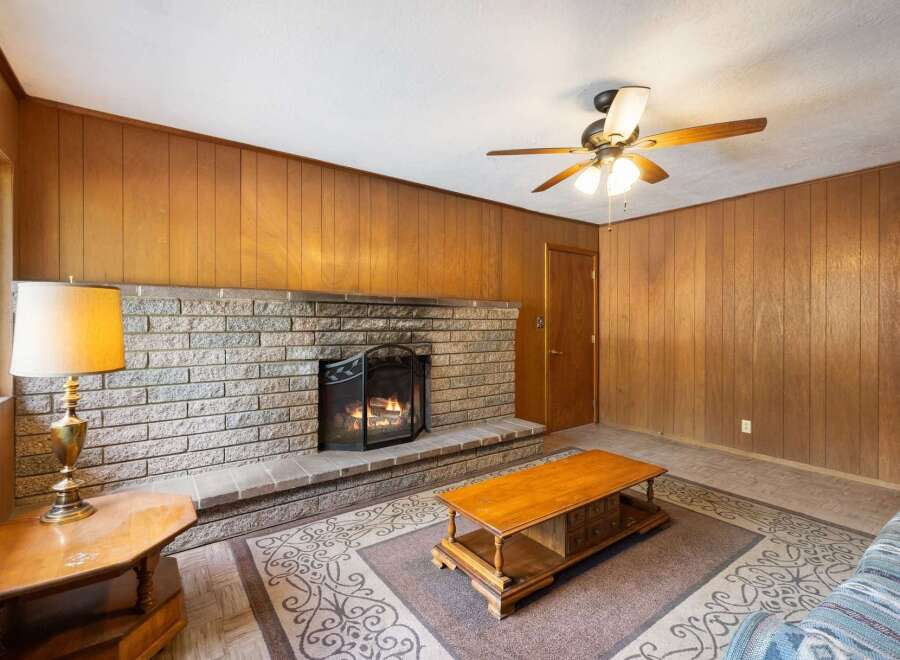 Cozy living room featuring a prominent brick fireplace with a lit fire, perfect for gathering on cool evenings.