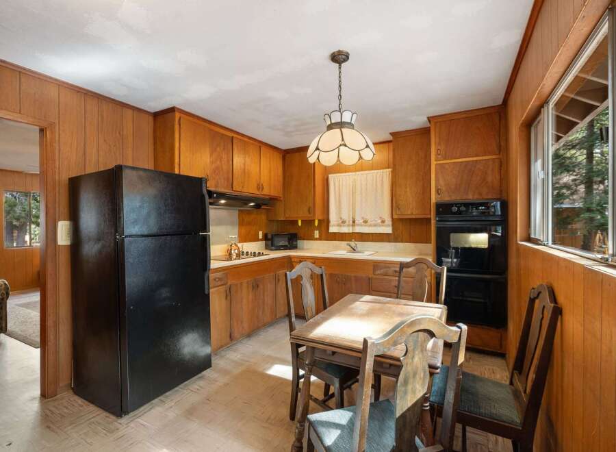 Step into this charming kitchen featuring warm wood paneling and ample cabinet space for all your storage needs.