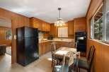 Step into this charming kitchen featuring warm wood paneling and ample cabinet space for all your storage needs.
