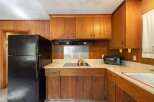 This charming kitchen features warm wood cabinetry and paneling, creating a cozy and inviting atmosphere.