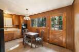 This charming kitchen features warm wood paneling and ample cabinetry, creating a cozy and functional space.