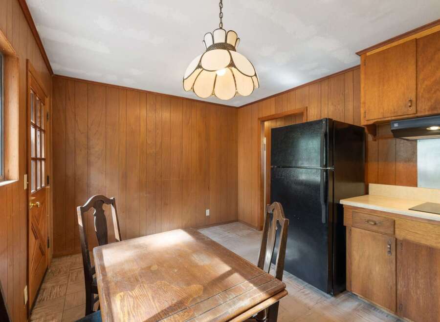 This charming kitchen features warm wood paneling throughout, creating a cozy and inviting atmosphere.
