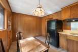 This charming kitchen features warm wood paneling throughout, creating a cozy and inviting atmosphere.