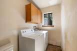 This laundry room features a white top-load washer and dryer set, perfect for handling your family's laundry needs.