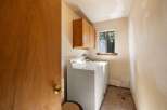 This laundry room features a white top-loading washing machine and a dryer, perfect for handling your household chores.