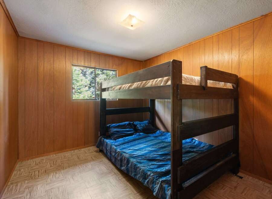This cozy bedroom features a sturdy wooden bunk bed, perfect for maximizing space and accommodating guests.