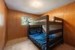 This cozy bedroom features a sturdy wooden bunk bed, perfect for maximizing space and accommodating guests.