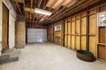 This spacious garage offers ample room for vehicles and storage, featuring a durable concrete floor and a sturdy overhead door.