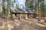 Nestled amongst tall pine trees, this charming home offers a serene retreat.