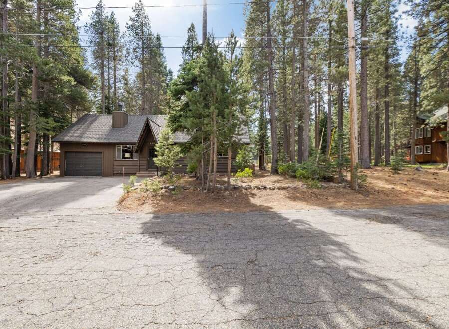 Nestled amongst tall pine trees, this charming brown home offers a serene mountain retreat.