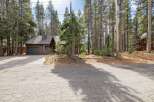Nestled amongst tall pine trees, this charming brown home offers a serene mountain retreat.