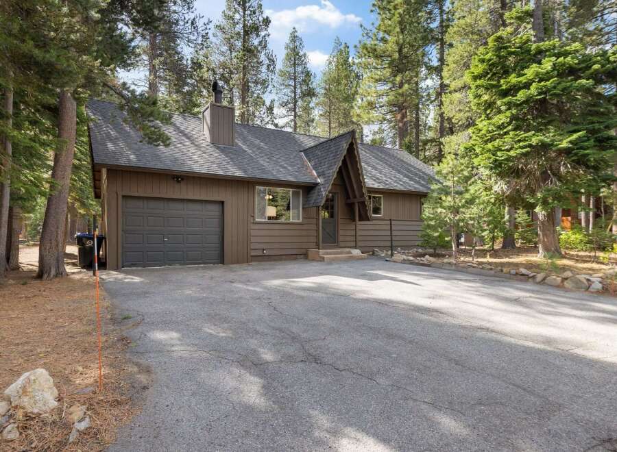 Nestled amidst tall pine trees, this charming brown home offers a serene retreat.