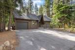 Nestled amidst tall pine trees, this charming brown home offers a serene retreat.