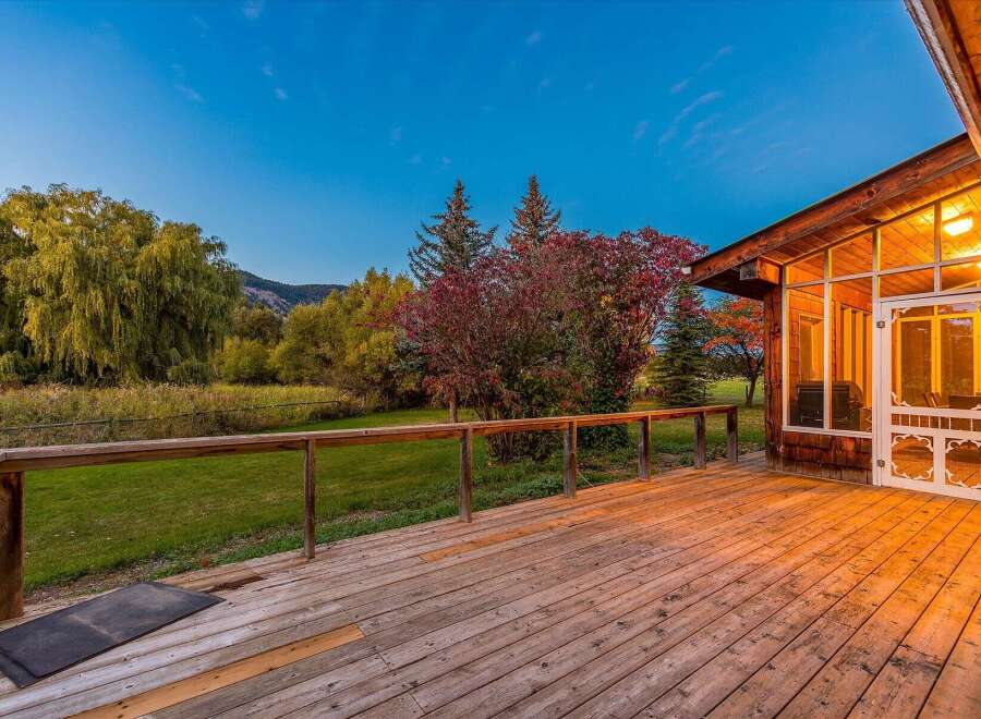 Enjoy breathtaking views from this expansive wooden deck, perfect for outdoor entertaining or quiet relaxation.