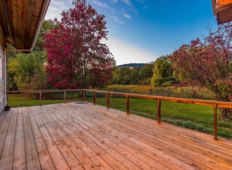 Enjoy the stunning autumn scenery from this expansive wooden deck, perfect for outdoor entertaining.