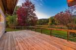 Enjoy the stunning autumn scenery from this expansive wooden deck, perfect for outdoor entertaining.
