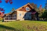 Experience rustic charm in this beautiful log cabin, nestled amidst vibrant autumn foliage.