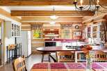 Experience rustic charm in this log cabin kitchen, featuring warm wood beams and paneling throughout.