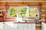 This charming kitchen features white cabinetry and a red countertop, providing a bright and inviting space.