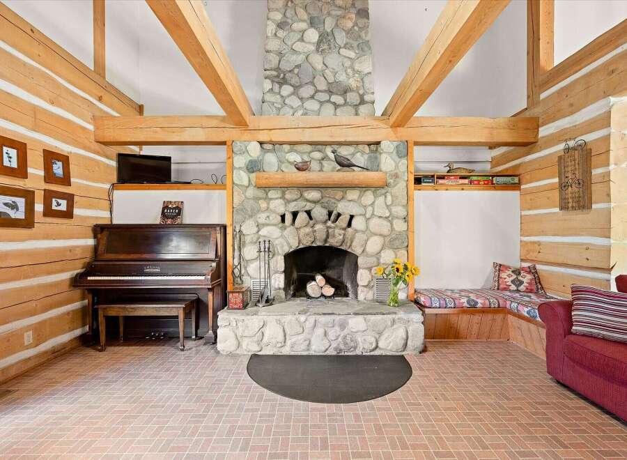 Experience rustic charm in this inviting living space, featuring a grand stone fireplace as the centerpiece.