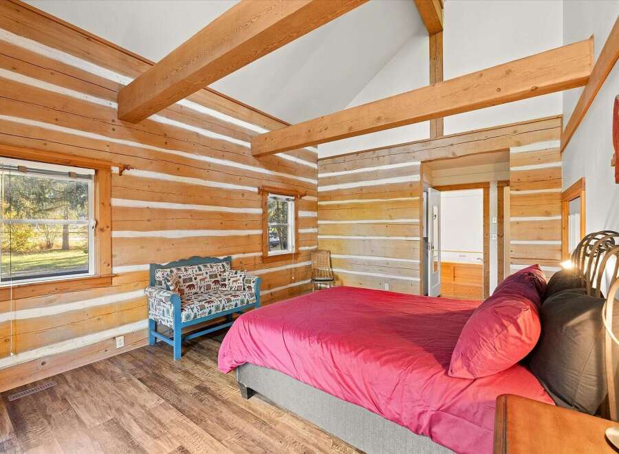 Experience rustic charm in this log cabin bedroom, featuring exposed wooden beams and a cozy, inviting atmosphere.