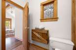 Step into a charming bathroom featuring rustic wooden accents and a beautiful stained-glass window.