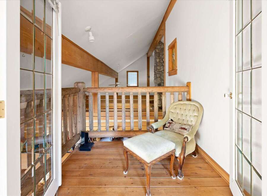 This charming loft area features a rustic wooden railing and exposed beams, creating a cozy and inviting atmosphere.