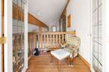 This charming loft area features a rustic wooden railing and exposed beams, creating a cozy and inviting atmosphere.