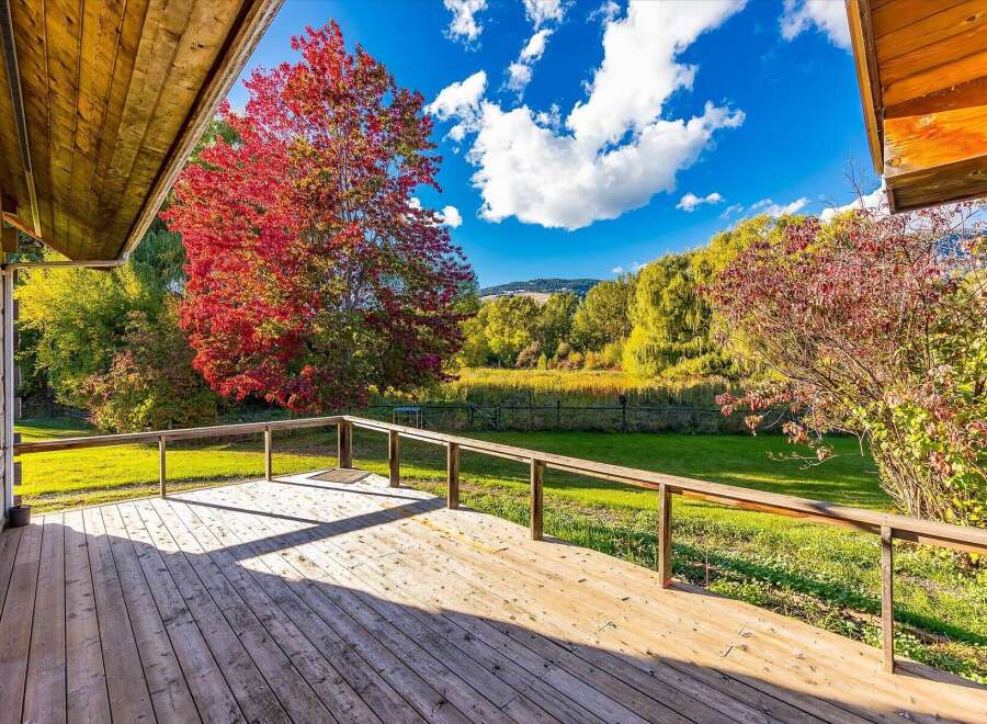 Enjoy the vibrant autumn colors from this charming wooden deck, perfect for outdoor relaxation and entertaining.