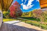 Enjoy the vibrant autumn colors from this charming wooden deck, perfect for outdoor relaxation and entertaining.