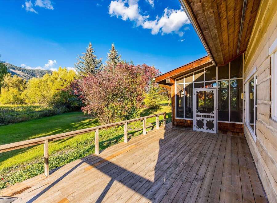 Enjoy the stunning natural beauty from this expansive wooden deck, perfect for outdoor living and entertaining.