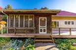 Charming rustic home featuring a welcoming screened-in porch perfect for enjoying the outdoors.