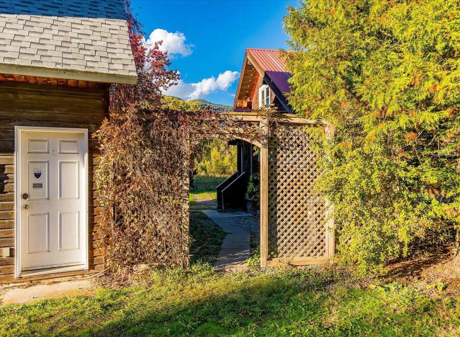 Discover this charming property featuring a rustic wooden exterior and a welcoming white door, perfect for a cozy retreat.