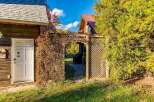 Discover this charming property featuring a rustic wooden exterior and a welcoming white door, perfect for a cozy retreat.