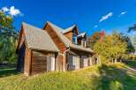 This charming wooden structure features a multi-level roof with dormer windows, offering ample natural light and character.