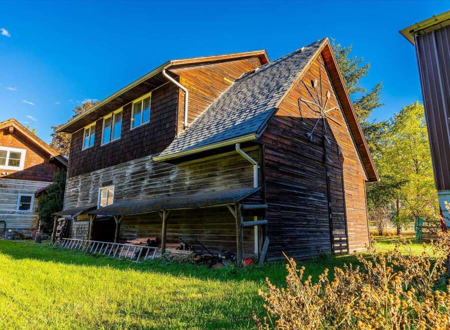 Discover rustic charm and ample space with this multi-story wooden structure, perfect for a workshop, storage, or conversion.