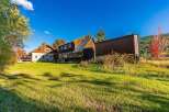 Discover this charming property featuring rustic log cabin architecture and a spacious screened-in porch, perfect for enjoying the serene surroundings.