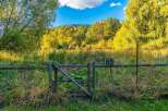 Discover this charming property featuring a rustic wooden fence with a gate, perfect for defining your outdoor space.