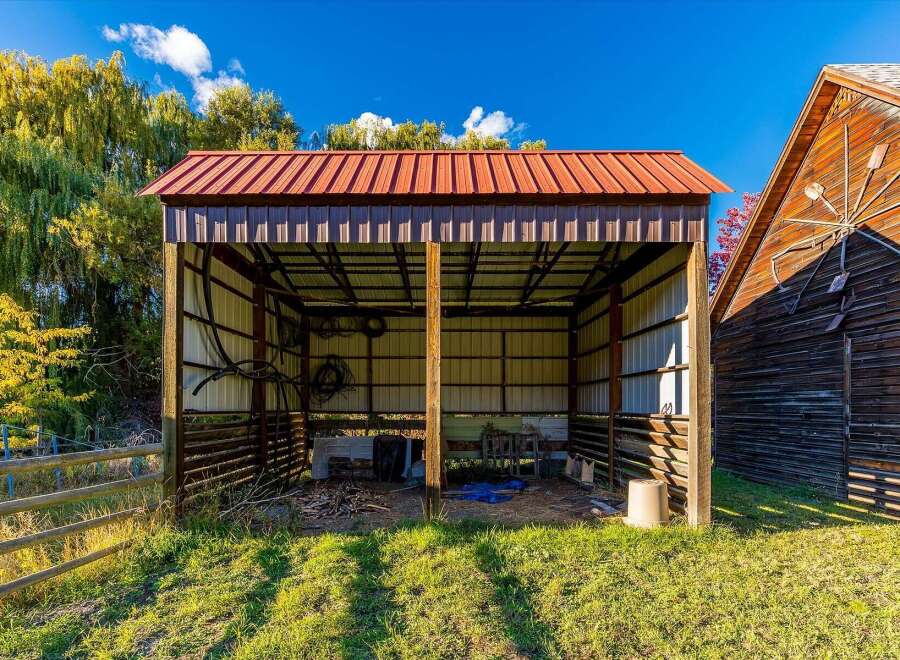 Discover this charming property featuring a spacious open-air barn with a durable metal roof, perfect for livestock or equipment storage.