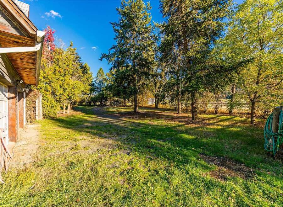 Discover this charming property featuring a rustic wooden exterior and a spacious, tree-lined yard perfect for outdoor activities.