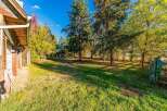 Discover this charming property featuring a rustic wooden exterior and a spacious, tree-lined yard perfect for outdoor activities.