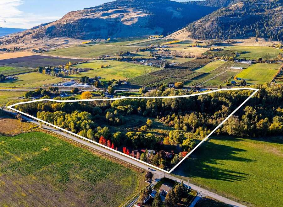 Discover this expansive property, highlighted by a white outline, nestled amidst rolling hills and agricultural fields.