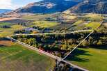 Discover this expansive property, highlighted by a white outline, nestled amidst rolling hills and agricultural fields.
