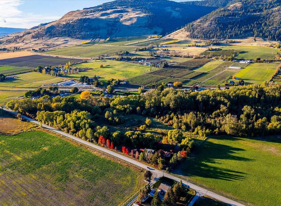 Discover this expansive property, highlighted by a white outline, nestled amidst rolling hills and agricultural fields.