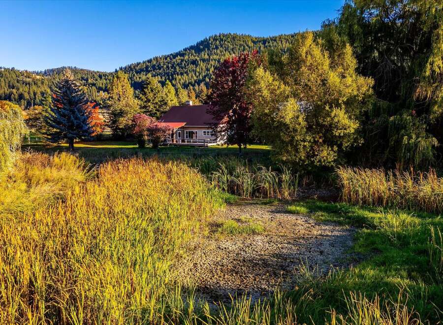Nestled amidst a vibrant autumn landscape, this charming home offers a serene retreat.